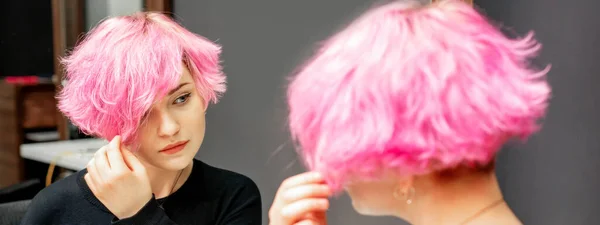 Красивая Молодая Белая Женщина Смотрит Свои Короткие Розовые Волосы Зеркало — стоковое фото