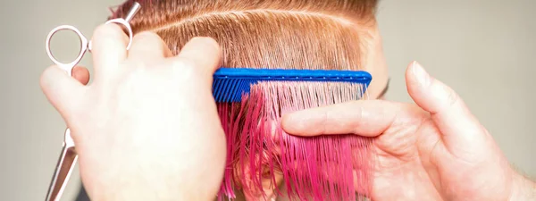 理发师的手在美容院里为一位年轻的高加索女人梳头 做短粉色的发型 — 图库照片