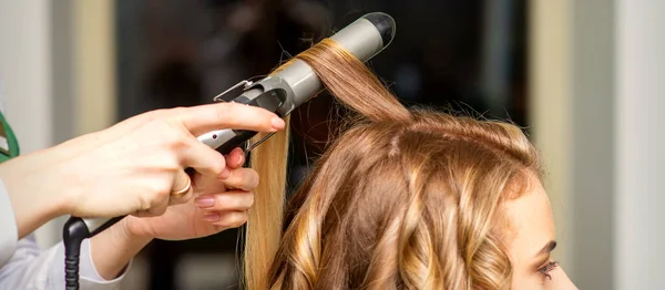 Fryzjer Robi Loki Lokówką Dla Młodej Kobiety Długimi Brązowymi Włosami — Zdjęcie stockowe