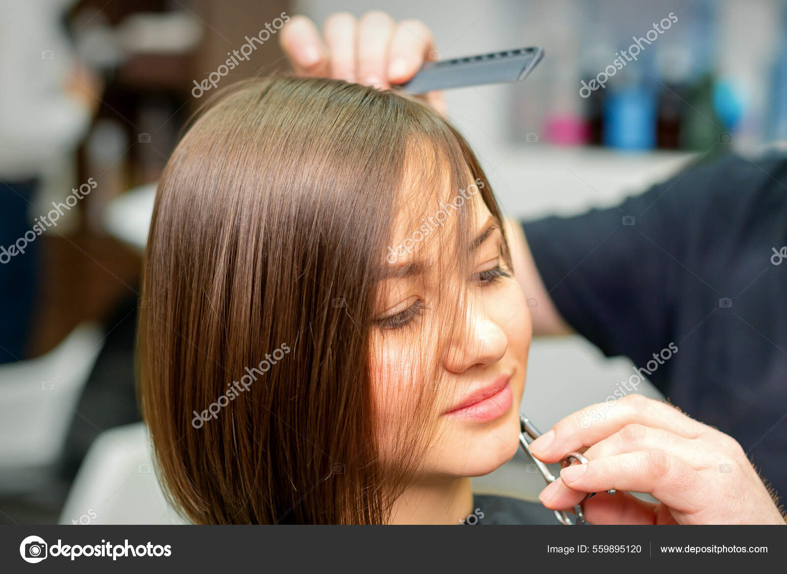 Cabeleireiro divide o cabelo feminino em seções com o pente segurando o  cabelo com as mãos em salão de cabeleireiro close-up.