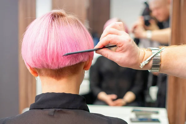 专业美发师用梳子在美发厅里梳短的粉色头发 女人的头发 后视镜 复制空间 后视镜 — 图库照片