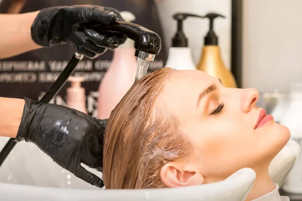 Młoda Kaukaska Kobieta Zamkniętymi Oczami Myje Włosy Przez Profesjonalnego Fryzjera — Zdjęcie stockowe