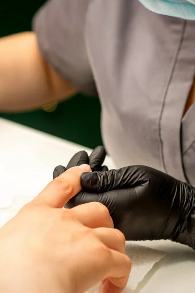 プロのマニキュアマスターを閉じる顧客の女性の手を保持し ネイルサロンで爪を消毒 — ストック写真