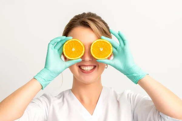 Portrait Young Caucasian Smiling Female Beautician Covering Eye Two Orange — Stock Photo, Image