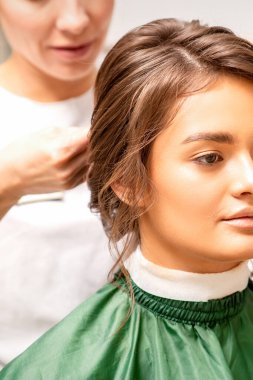 Saç şekillendirici gelin. Bir kadın kuaför, güzellik salonunda güzel beyaz bir kadın için kuaförlük yapıyor.