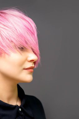 Kısa düz kısa saçlı, pembe renkli, gözleri kapalı ve fotokopi alanı ile boyanmış güzel beyaz bir kadının profili.