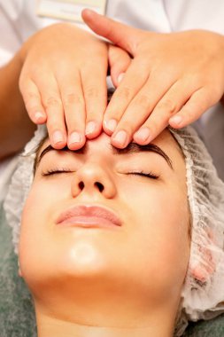 Kafa masajı. Kafkasyalı beyaz güzel bir kadın kaplıca salonundaki kapalı gözlerle kafa ve alın masajı yaptırıyor.