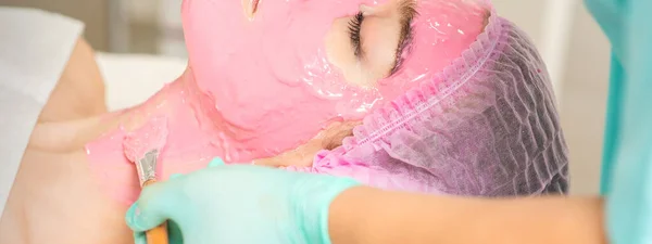 Hand Van Cosmetoloog Het Aanbrengen Van Roze Alginemasker Met Borstel — Stockfoto