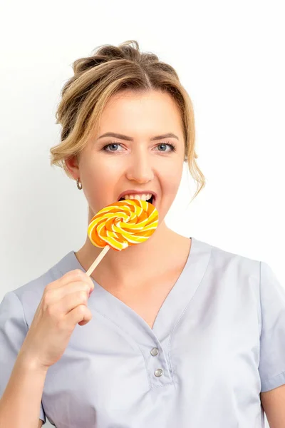 Portrait Beautiful Young Caucasian Beautician Wearing Medical Shirt Bites Lollipop — Stock Photo, Image