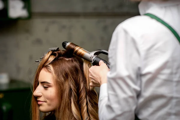 Die Friseurin Kräuselt Einem Schönheitssalon Haare Für Eine Junge Kaukasische — Stockfoto