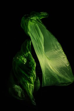 Koyu arkaplanda yeşil örtülü kız