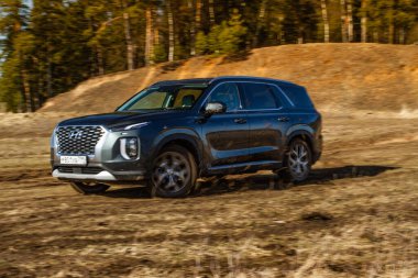 MOSCOW, RUSSIA - 10 Nisan 2021 Hyundai Palisade LX2 dış görünüm hareket halinde. Orta büyüklükte bir arazi aracı arazide ve toprakta ilerliyor. Off-road engeli