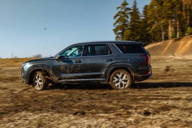 MOSCOW, RUSSIA - 10 Nisan 2021 Hyundai Palisade LX2 dış görünüm hareket halinde. Orta büyüklükte bir arazi aracı arazide ve toprakta ilerliyor. Off-road engeli