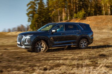 MOSCOW, RUSSIA - 10 Nisan 2021 Hyundai Palisade LX2 dış görünüm hareket halinde. Orta büyüklükte bir arazi aracı arazide ve toprakta ilerliyor. Off-road engeli