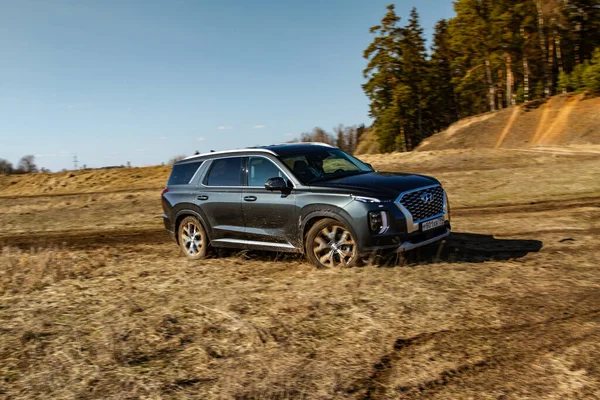 MOSCOW, RUSSIA - 10 Nisan 2021 Hyundai Palisade LX2 dış görünüm hareket halinde. Orta büyüklükte bir arazi aracı arazide ve toprakta ilerliyor. Off-road engeli