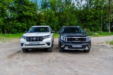 MOSCOW, RUSSIA - 23 Mayıs 2021 Kia Mohave ayrıca Kia Borrego İkinci nesil HM2 ve Toyota Land Cruiser Prado modelini 2021 olarak adlandırdı. Şehirdeki modern SUV ve doğa arka planı. Ön taraf görünümü.