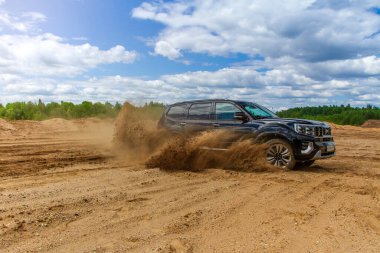 MOSCOW, RUSSIA - Haziran 02, 2021 Kia Mohave ayrıca Kia Borrego ikinci nesil yüz gerdirme ameliyatı olarak adlandırıldı. 2021 model SUV, doğa arka planı. Kia Mohave kumda hareket halinde..