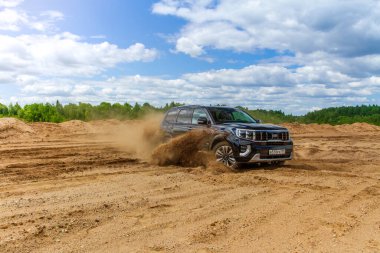 MOSCOW, RUSSIA - Haziran 02, 2021 Kia Mohave ayrıca Kia Borrego ikinci nesil yüz gerdirme ameliyatı olarak adlandırıldı. 2021 model SUV, doğa arka planı. Kia Mohave kumda hareket halinde..