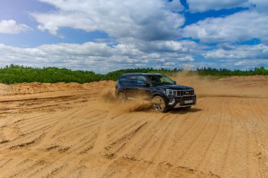 MOSCOW, RUSSIA - Haziran 02, 2021 Kia Mohave ayrıca Kia Borrego ikinci nesil yüz gerdirme ameliyatı olarak adlandırıldı. 2021 model SUV, doğa arka planı. Kia Mohave kumda hareket halinde..