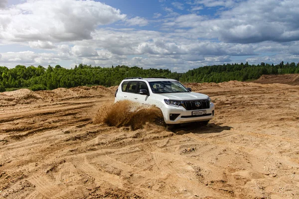 MOSCOW, RUSSIA - Haziran 02, 2021 Toyota Land Cruiser Prado modeli 2021. 2021 model SUV, doğa arka planı. Toyota Land kruvazörü Prado kumda hareket halinde..