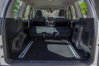 Minibüsün içinde kocaman, temiz ve boş bir araba bagajı var. Bagajı açık bir SUV 'nin arka görüntüsü.