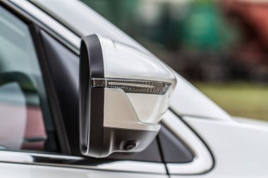 Arabanın yan aynasının önünü kapat. Arabanın camında ön dikiz aynası var. Arabanın dış detayları..