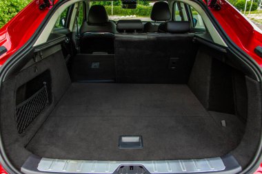 Minibüsün içinde kocaman, temiz ve boş bir araba bagajı var. Bagajı açık bir SUV 'nin arka görüntüsü.