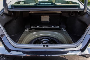 Modern bir arabanın bagajında yedek tekerlek. Jack kaldırıyor ve arabanın arkasında yedek lastik var..