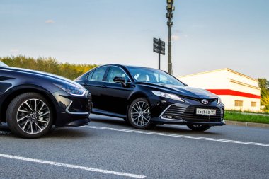 MOSCOW, RUSSIA - AUGust 15, 2021 Hyundai Sonata 8. nesil (DN8) ve Toyota Camry (XV70), orta büyüklükte bir sedan otomobil modeli 2021 yılında şehir arka planında. Dış cephe yakın görünümü.