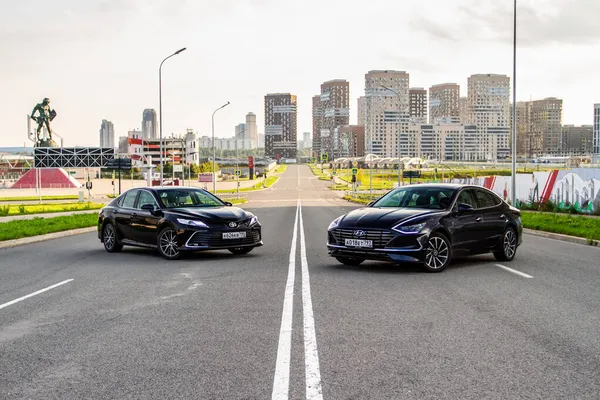 MOSCOW, RUSSIA - AUGust 15, 2021 Hyundai Sonata 8. nesil (DN8) ve Toyota Camry (XV70), orta büyüklükte bir sedan otomobil modeli 2021 yılında şehir arka planında. Dış cephe yakın görünümü.