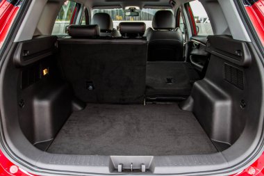 Minibüsün içinde kocaman, temiz ve boş bir araba bagajı var. Bagajı açık bir SUV 'nin arka görüntüsü.