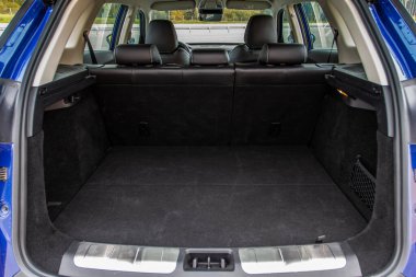 Minibüsün içinde kocaman, temiz ve boş bir araba bagajı var. Bagajı açık bir SUV 'nin arka görüntüsü.