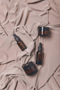 Beyaz zemin üzerinde sıvı bulunan kozmetik şişeleri