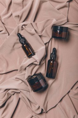 Beyaz zemin üzerinde sıvı bulunan kozmetik şişeleri