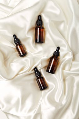 Beyaz zemin üzerinde sıvı bulunan kozmetik şişeleri