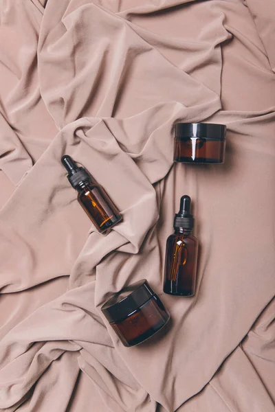 Beyaz zemin üzerinde sıvı bulunan kozmetik şişeleri