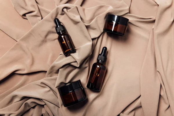 Beyaz zemin üzerinde sıvı bulunan kozmetik şişeleri