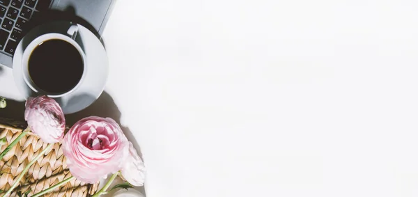 Çiçekli kahve fincanı ve beyaz arka planda dizüstü bilgisayar