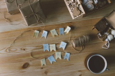 Üzerinde bir fincan kahve ve beyaz arka planda bir defter olan ahşap bir masanın üst görüntüsü.