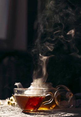 Bir fincan limonlu ve yeşil yapraklı çay.