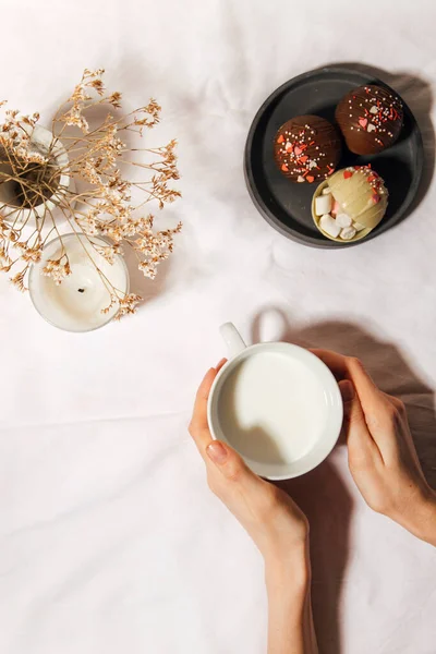 Frau Hält Tasse Kaffee Und Kekse Auf Weißem Tisch — Stockfoto