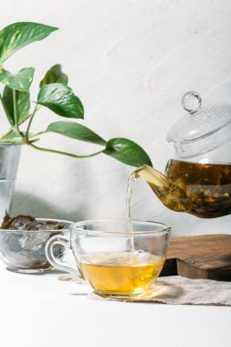Beyaz arka planda cam çaydanlıkta çay
