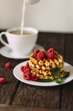 Waffle ve böğürtlenli kahvaltı beyaz ahşap masada