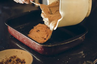 Bir adamın elini siyah arka planda bir kaşık ve bıçakla kapat.