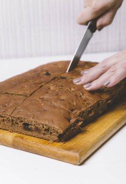 Adam bir parça ekmek kesiyor.