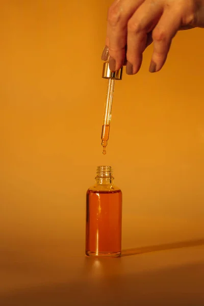 Mano Femenina Con Botella Aceite Frasco Vidrio Sobre Fondo Amarillo — Foto de Stock