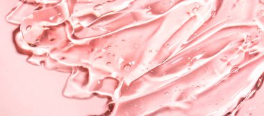 Pastel pembe arka planda hava kabarcıkları olan şeffaf kozmetik serumu ürünü.