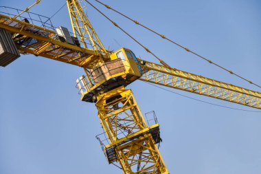 İnşaat alanında mavi gökyüzüne karşı kule vinci.