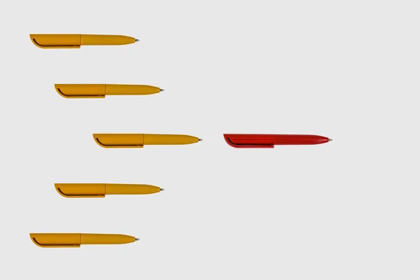 Muchos Bolígrafos Amarillos Siguen Bolígrafo Rojo Sobre Fondo Papel Blanco —  Fotos de Stock