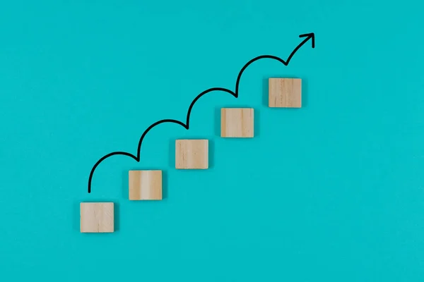 Tahta bloklar merdivenleri kapatıyor. Hedefe doğru ilerliyorlar. Büyüme, artış, hedefe ulaşma ve sonuç kavramı